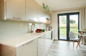 Ground floor: Open-plan kitchen/dining/living area with bi-fold doors opening to private decked area