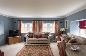 The Mill House - sitting room with two double sofas and TV