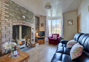 The spacious living/dining room has laminate flooring and a wood burning stove