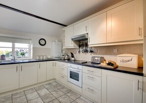 The spacious kitchen is fitted with modern units and has an electric cooker, microwave, fridge/freezer, tumble dryer and dishwasher.