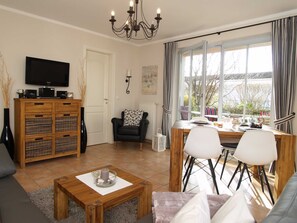 das gemütliche Wohnzimmer mit Essecke, Flachbild-TV und Zugang zur Terrasse