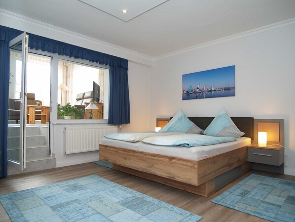 Das Schlafzimmer mit Doppelbett und Zugang zum Wintergarten