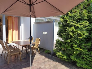 Terrasse mit Möbeln und Schirm