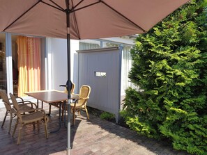 Terrasse mit Möbeln und Schirm