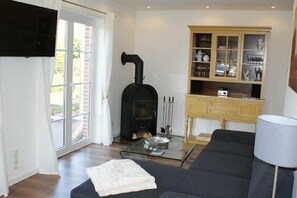 Wohnzimmer mit Kaminofen und Ausgang zur Terrasse