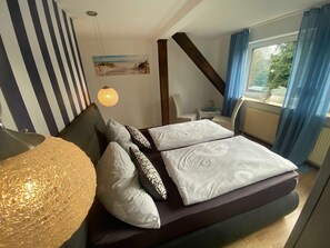 Schlafzimmer 1 mit Boxspringbett und Außenjalousien. 