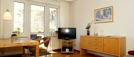 Das Wohnzimmer mit Sitzecke, Flachbild-TV und Zugang zur Terrasse