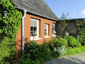 Das Ferienhaus von der Südseite mit Eingangsbereich links hinten bei der überdachten Terrasse