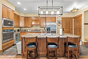 Full size kitchen with stainless steel appliances and granite countertops.