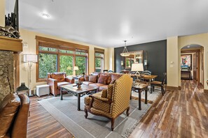 The living area features a flat screen TV above a gas fireplace, ample seating and access to the main private balcony.