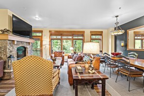 The living area features a flat screen TV above a gas fireplace, ample seating and access to the main private balcony.