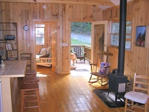Great/Main room w/ woodstove & kitchen; front deck w/ the late/great Gracie