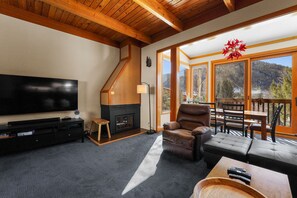 Sunken living room area with ample seating and flat screen TV.