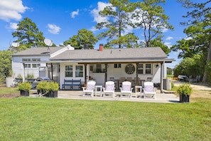 Backyard: reclining Adirondack chairs with ottomans, grassy area, table seating 