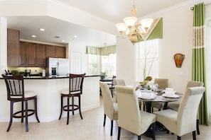 The dining area offers seating for 6 with 2 stools at the breakfast bar