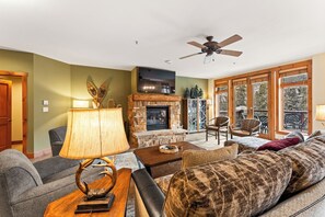 Spacious living area featuring cozy seating for your whole group, a gas fireplace, mounted flat screen TV and access to the main private balcony.