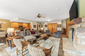 Spacious living area featuring cozy seating for your whole group, a gas fireplace, mounted flat screen TV and access to the main private balcony.