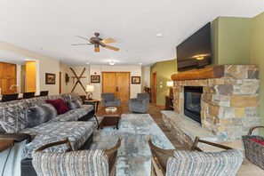 Spacious living area featuring cozy seating for your whole group, a gas fireplace, mounted flat screen TV and access to the main private balcony.