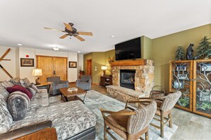 Spacious living area featuring cozy seating for your whole group, a gas fireplace, mounted flat screen TV and access to the main private balcony.