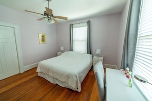 Pink bedroom sweet with a queen bed, desk & chair, side tables.