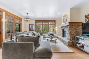 The living area features a flat screen TV, a gas fireplace and a queen-sized sleeper sofa.