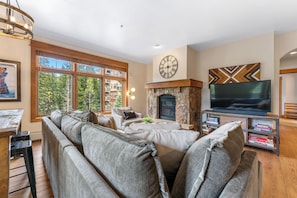The living area features a flat screen TV, a gas fireplace and a queen-sized sleeper sofa.