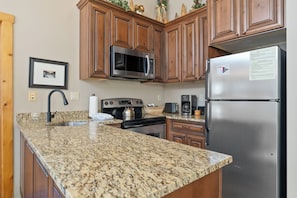 Full kitchen with stainless steel appliances and granite countertops.
