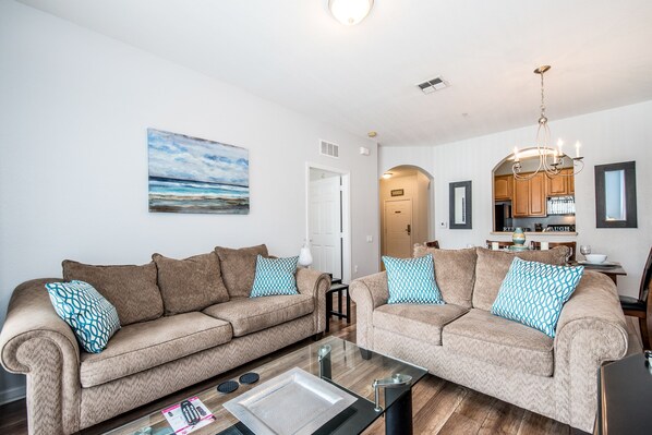 This cozy living area is strategically located beside the dining table and kitchen, providing effortless access to the private balcony for relaxing outdoor moments.