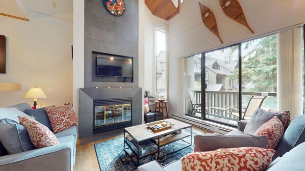 Sunken living area w/ a cozy wood-burning fireplace and cable tv