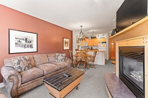Living area with a gas fireplace, TV, and queen sleeper sofa.