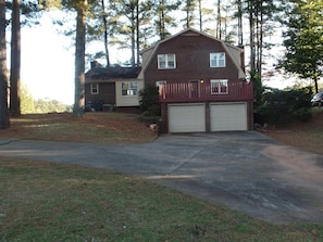 Back of house with ample parking on concrete.