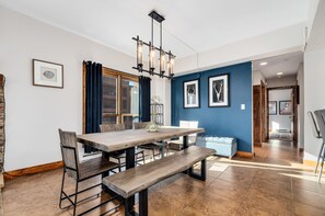 6-7 adults fit comfortably at the dining table, with 4 more seats at the counter