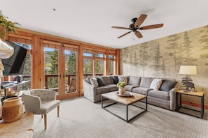 Living area offering cozy furnishings, gas fireplace and private balcony access.