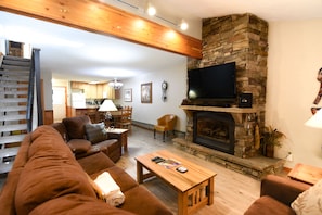 Living Room Area - Living room with a large couch, flat screen TV, and cozy fireplace.