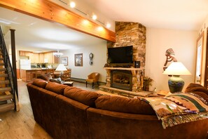 Living Room Area - Living room with a large couch, flat screen TV, and cozy fireplace.