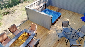 Deck with plenty of space for guests with a peek at the hot tub.