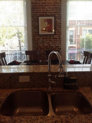 Kitchen Sink view to Dining table with floor to ceiling  windows