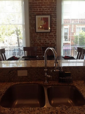 Kitchen Sink view to Dining table with floor to ceiling windows