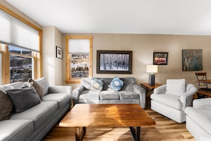 The living area featuring a queen-sized sleeper sofa, flat screen TV, gas fireplace and access to the private balcony.