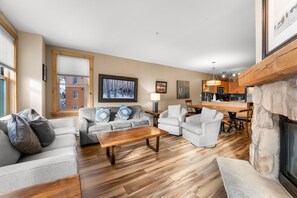 The living area featuring a queen-sized sleeper sofa, flat screen TV, gas fireplace and access to the private balcony.