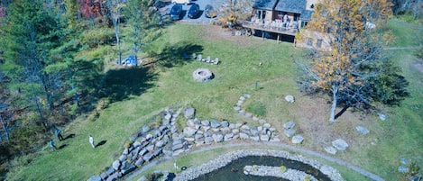 Drone Shot of The "backyard"  Note 80ft diameter swimming pond and huge firepi