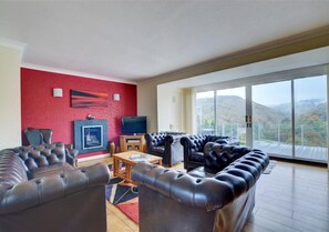 The sitting room has huge French windows leading out to the terrace and comfy Chesterfield leather sofas