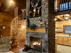 The living room has a beautiful stone fireplace that gives warmth to the lodge.