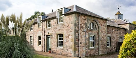 Crailing Coach House - the exterior view of the cottage with beautiful stone walls