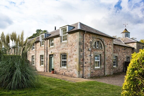 Crailing Coach House - the exterior view of the cottage with beautiful stone walls