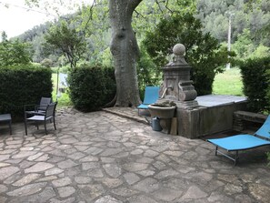 Terrasse ombragée avec une fontaine alimentée par une source. Terrace with a fontain fed by a spring