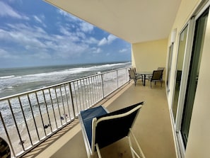 The balcony is HUGE! And features a chaise lounger and dining set for everyone to relax in!