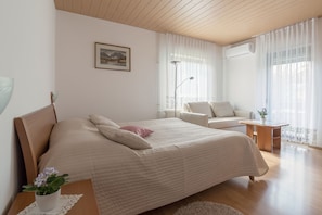 A large king size bed (180 x 200 cm) and a three-seat sofa in the first bedroom.