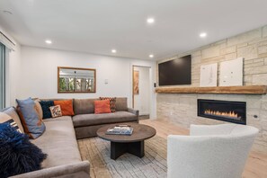 The living room with a comfortable sectional sofa, flat screen TV and gas fireplace is a perfect spot to unwind during your visit to Aspen!