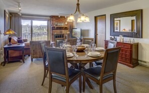 Great room featuring set round dining table and chairs. Living area in background.